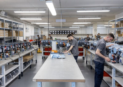 Immagine di un laboratorio con diverse apparecchiature elettriche e personale al lavoro
